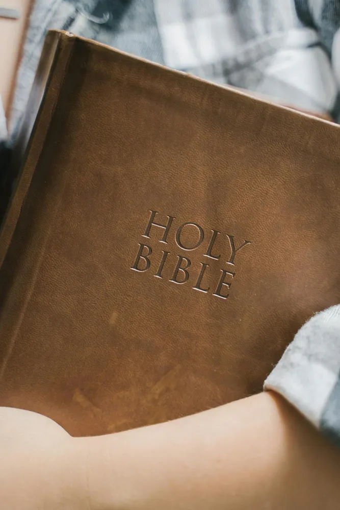 Holding a brown Bible